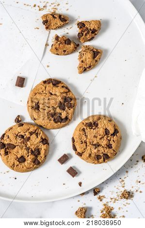 Cookies with dark chocolate chips on white plate.