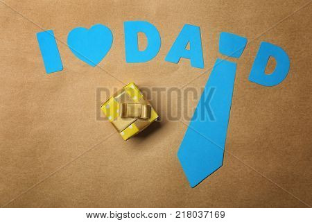 Composition with phrase I LOVE DAD and gift for Father's Day on craft paper