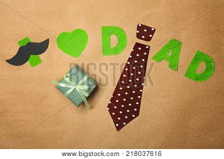 Composition with phrase I LOVE DAD and gift for Father's Day on craft paper
