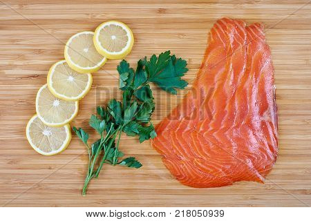 Fillet trout with fresh herbs and lemon on a board.