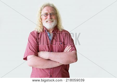 Portrait of smiling senior man. Cheerful aged man standing with his arms folded. Happy elderly man in glasses