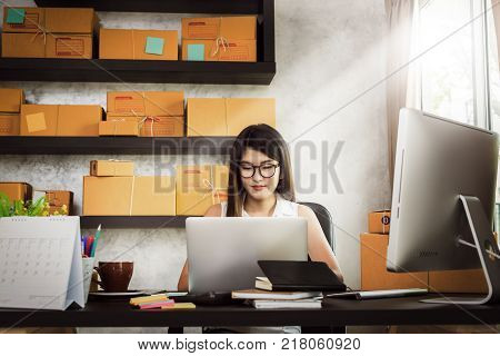 Charming beautiful asian teenager owner business woman work at home for online shoppingwriting the order and preparing package product with office equipment entrepreneur life style concept