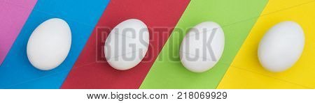 Easter Eggs on colorful background. The concept of a holiday and a happy Easter. Top view. Copy space. Easter mock up.