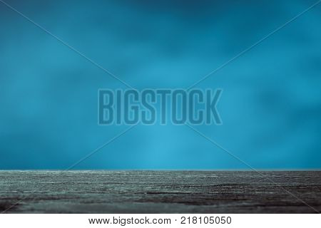 Empty brown wood table top on blue background. Used for display or montage your products.