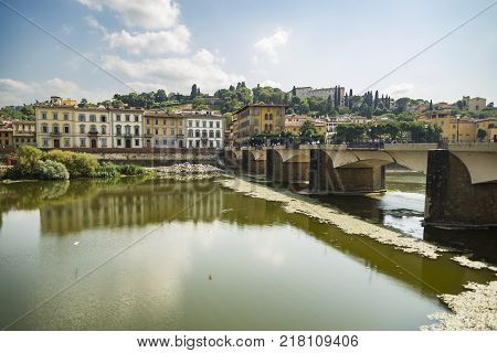 Scenic view of the Lungarno at historic center of Florence Italy. Facades of old medieval houses on waterfront of the Arno River. Florence is a popular tourist destination of Europe.