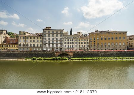 Scenic view of the Lungarno at historic center of Florence, Italy. Facades of old medieval houses on waterfront of the Arno River. Florence is a popular tourist destination of Europe.