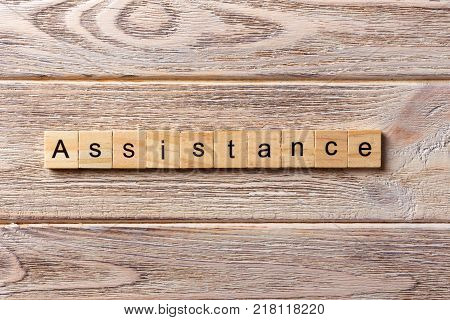 ASSISTANCE word written on wood block. ASSISTANCE text on table concept.