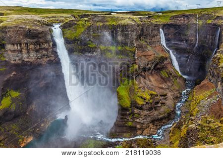  Complex of high waterfalls of Haifoss in a dangerous tundra canyon. Turquoise water at the base of the waterfall. The concept of extreme and phototourism