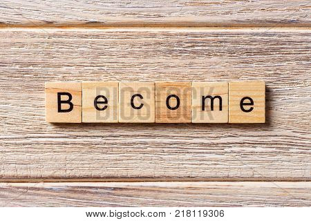 Become word written on wood block. Become text on table concept.