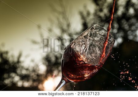 Pouring the wine at sunset, yellow grey background