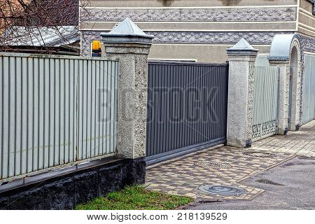 gray iron fence with closed door in the street