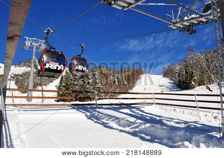 Jasna Slovakia - December 1 2017: View of the ski slopes and cabins of the cableway at the station on the south side of Mount Chopok on a sunny day in the ski resort Jasna Low Tatras Slovakia.