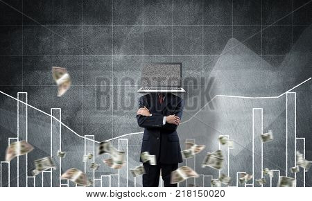Businessman in suit with laptop instead of head keeping arms crossed while standing against flying dollars and analytical charts drawn on wall on background. 3D rendering.
