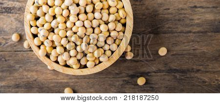 Soybean in wood bowl on wooden background. Soybeans Top view. Soybeans banner panoramic crop for copy space. Soybeans
