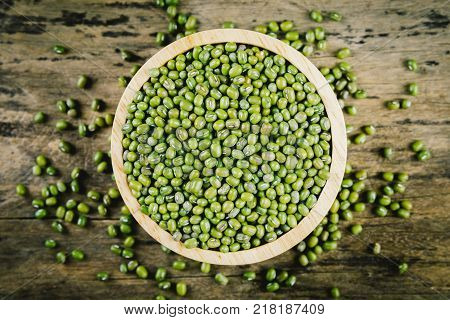 Mung bean green moong dal in cup. Copy space. Wooden background. top view.