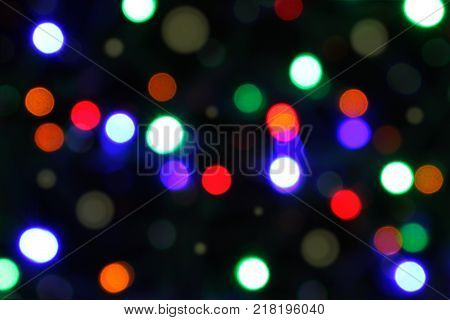 Celebration atmosphere. Bokeh of multicolored highlights on a black background.