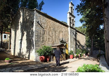 Priest in front of orthodox church in Lasithi plateau at Crete island - Greece