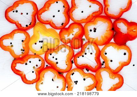Sliced bolgarian paprika red and yellow pepper and black pepper peases