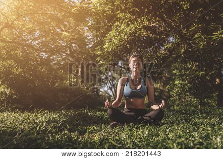 Yoga in the park outdoor with effect light health woman Yoga woman. Concept of healthy lifestyle and relaxation. vintage tone. yoga in park. girl yoga relex. yoga fitness. yoga concept.