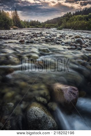 Bela River with Water Flowing over the Rocks at Sunset in Slovakia