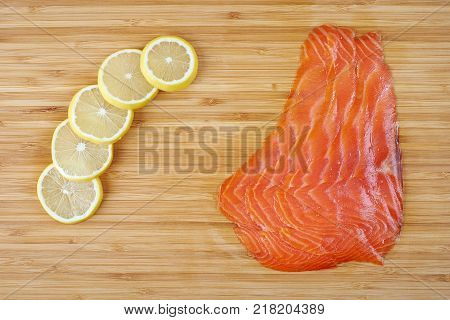 Smoked Fillet trout with lemon on a cutting board. Seafood.