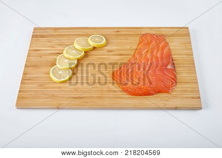 Smoked Fillet salmon with lemon on a board. Seafood.