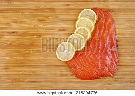 Smoked Fillet trout with lemon on a cutting board. Seafood.