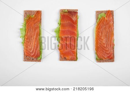 Low caloric open sandwich with red fish. Isolated on white background.