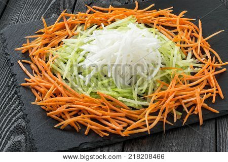 Ingredients for preparation of vitamin salad. Straw of carrots daikon and radishes on slate board. Detox products. Prevention of avitaminosis influenza and colds. Vegetarian healthy and diet food