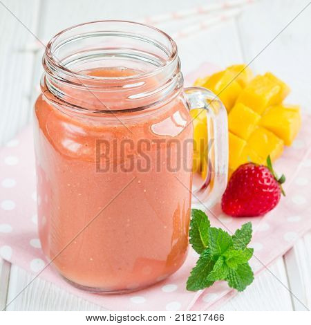 Healthy smoothie with strawberry mango and banana in a glass jars square format