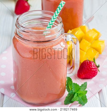 Healthy smoothie with strawberry mango and banana in glass jars square format