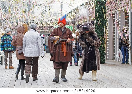 Moscow Russia - February 25 2017: Buffoon with balalaika and bear at Russian national festival 