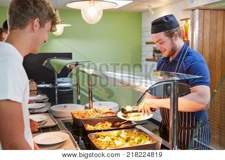 Teenage Students Being Served Meal In School Canteen