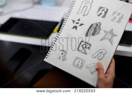 Hand Holding Notebook With Drew Brand Logo Creative Design Ideas