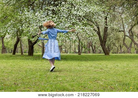 Happy Woman in the Blossoming Spring Garden