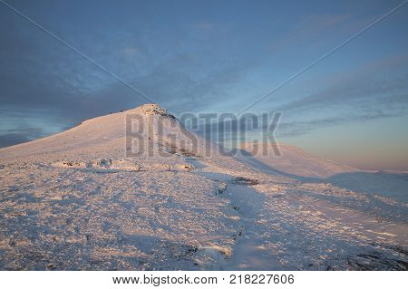 Winter snow scene at dusk on Pen y Fan mountain in the Brecon Beacons National Park, UK. A popular location for serious walkers and hikers.