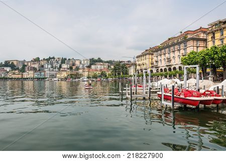Lugano Switzerland - May 28 2016: View of embankment of Lugano Lake. Lake Lugano (Lago di Lugano) is nestled between Lake Maggiore and Lake Como and lies partly in Switzerland and partly in Italy.