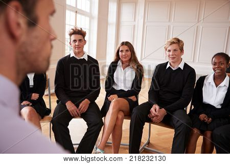 Group Of Teenage Students Having Discussion With Tutor