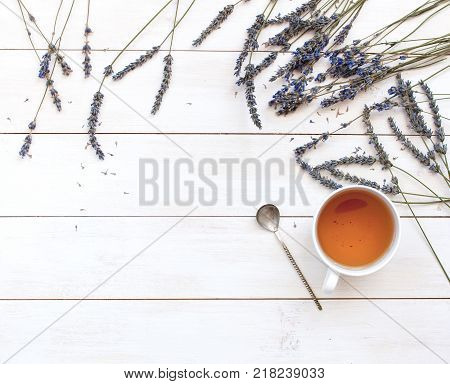 A cup of hot tea and lavender on a white wooden background top view. Herbal tea Hot drink Mood Lavender