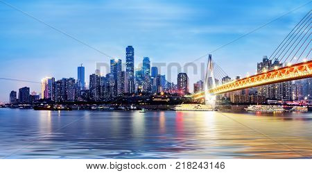 cityscape and skyline of downtown near water of chongqing at night