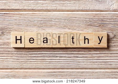healthy word written on wood block. healthy text on table concept.