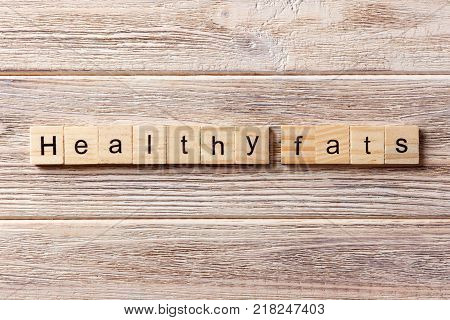 Healthy fats word written on wood block. Healthy fats text on table concept.