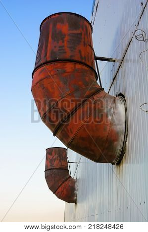 Close up obsolete rusty metal pipes on wall of factory