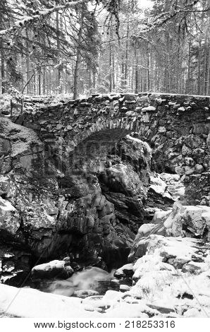 A view of a stone arch bridge above the falls of Bruar