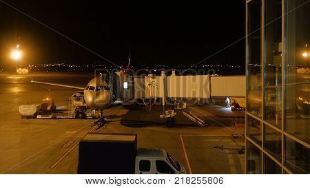 Close View Of Aircraft Fuselage Near The Entering Baggage Door At Night. Plane Takes Passengers. Tim