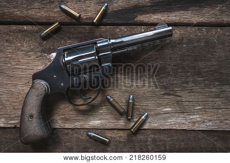 Gun and ammunition on wooden table. top view
