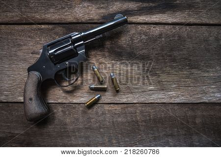Gun and ammunition on wooden table. top view