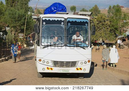 LALIBELA, ETHIOPIA - JANUARY 27, 2010: Unidentified people travel by bus passing by the street in Lalibela, Ethiopia.