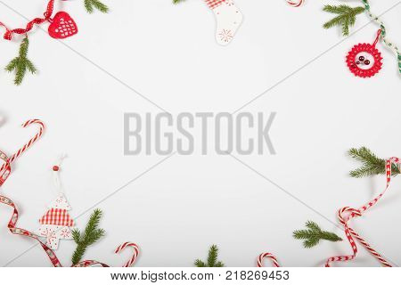 Christmas holiday composition. Festive creative red pattern, xmas handmade decor holiday with ribbon, candy canes, gift, christmas tree and decorations on white background. Flat lay, top view