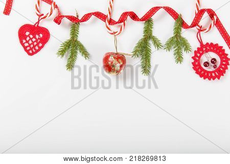 Christmas holiday composition. Festive creative red pattern, xmas handmade decor holiday with ribbon, candy canes, gift, christmas tree and decorations on white background. Flat lay, top view